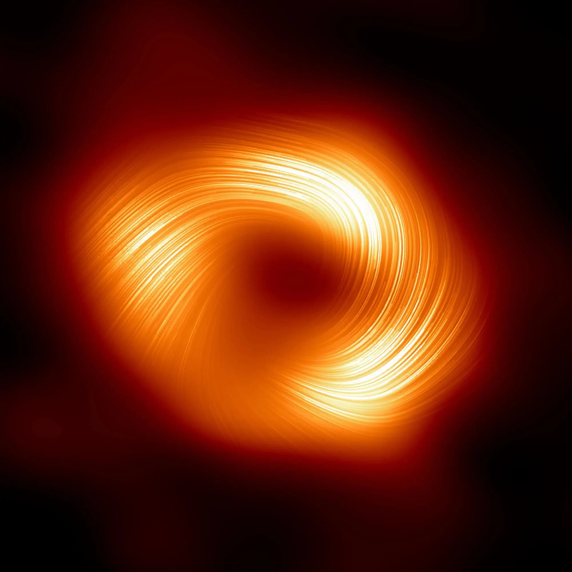 Strong magnetic fields spiraling at the edge of the Milky Way’s central black hole